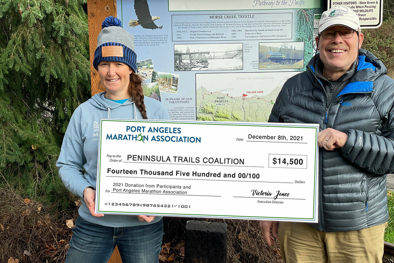 Jeff Bohman, of the Peninsula Trails Coalition and Race Director Victoria Jones with the presentation of the Donated Check. Taken at the Morse Creek ODT Trailhead.  (Photo Credit: Dave Lasorsa)