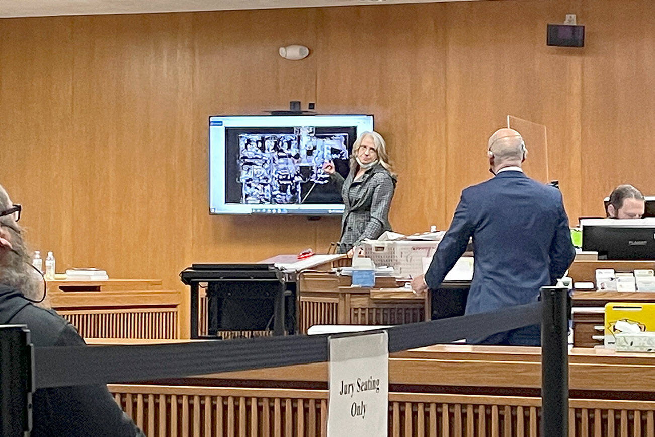Noreen “Reenie” Iverson, ex-wife of Darrell Iverson and mother of Jordan Iverson, points to a layout of the home at 52 Bear Meadow Road during Dennis Marvin Bauer’s triple-murder trial in Clallam County Superior Court. (Rob Ollikainen/for Peninsula Daily News)
