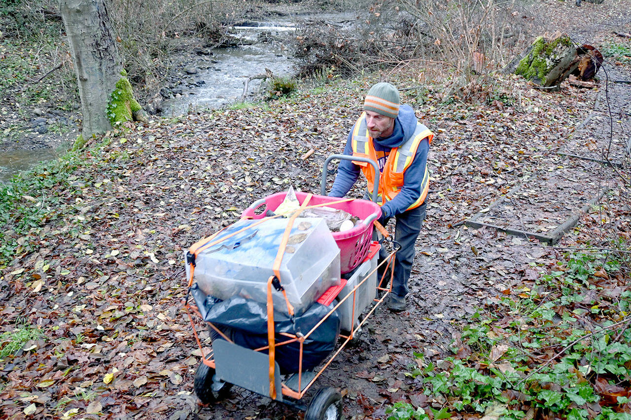 Paul Gottlieb/Peninsula Daily News
Joe DeScala pushes a shopping cart of trash collected from along Peabody Creek Trail in Port Angeles to his truck.