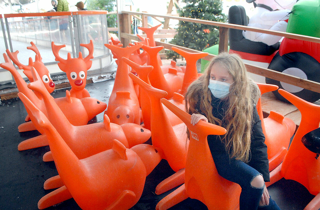 Madison Estus, 10, of Lacey takes a break from ice skating among a collection of skating aids at the Port Angeles Winter Ice Village over the weekend. The village offers daily ice skating from 9 a.m. to 9 p.m. through Jan. 3. (Keith Thorpe / Peninsula Daily News)