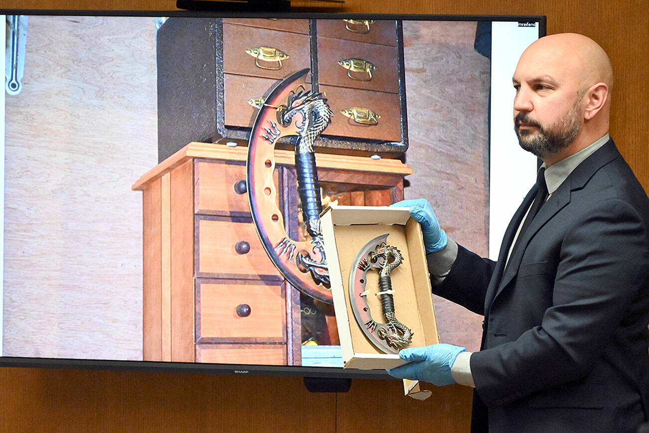 Paul Gottlieb/Peninsula Daily News
Port Angeles Police Department Detective Jeff Ordona on Friday displays a knife found in Dennis Bauer's cabin during testimony at Bauer's murder trial linking items found at the residence with a triple homicide.