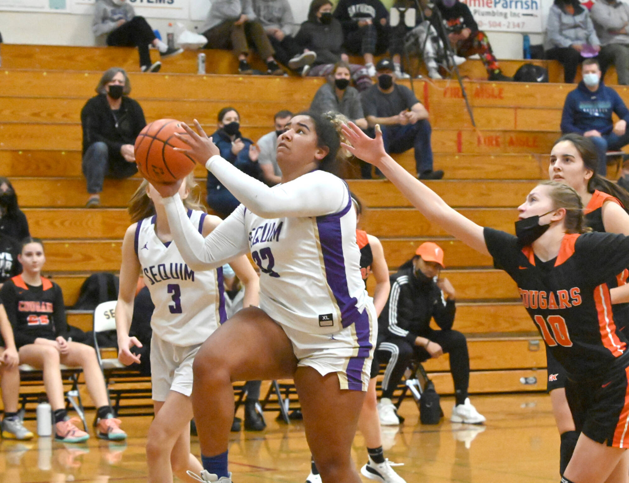 Sequim's Jelissa Julmist drives to the basket against Central Kitsap on Monday in Sequim. Also in on the play is Sequim's Sammie Bacon (3). (Michael Dashiell/Olympic Peninsula News Group)