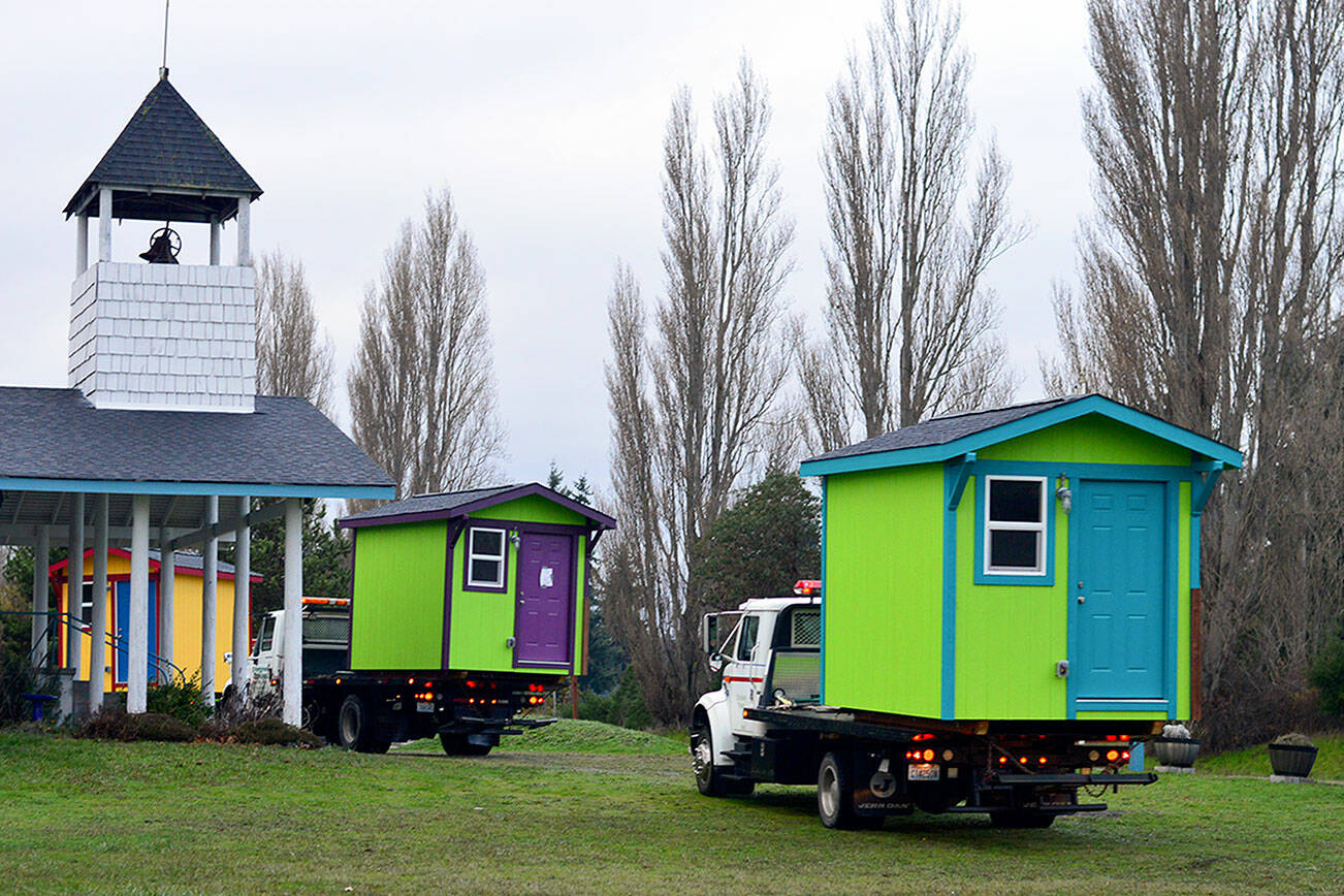 The tiny homes built in the field beside the Evangelical Bible Church in Port Townsend were transported Thursday morning to Pat’s Place, the new transitional housing village a mile and a half away. (Diane Urbani de la Paz/Peninsula Daily News)