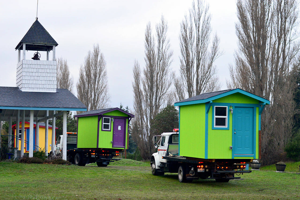 The tiny homes built in the field beside the Evangelical Bible Church in Port Townsend were transported Thursday morning to Pat’s Place, the new transitional housing village a mile and a half away. (Diane Urbani de la Paz/Peninsula Daily News)