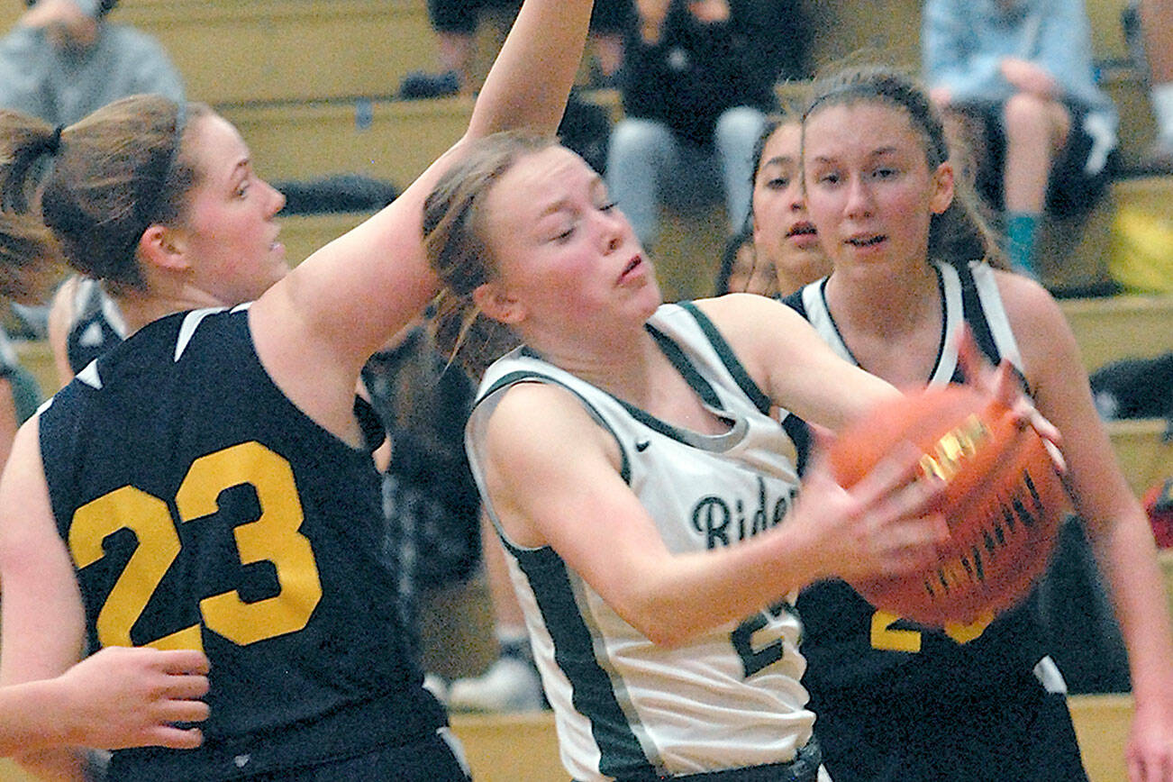 Keith Thorpe/Peninsula Daily News
Port Angeles' Anna Petty, center, pulls down a rebound surrounded by Bainbridge's Macy Kingrey, left, and Grace Colburn, right, on Thursday at Port Angeles High School.