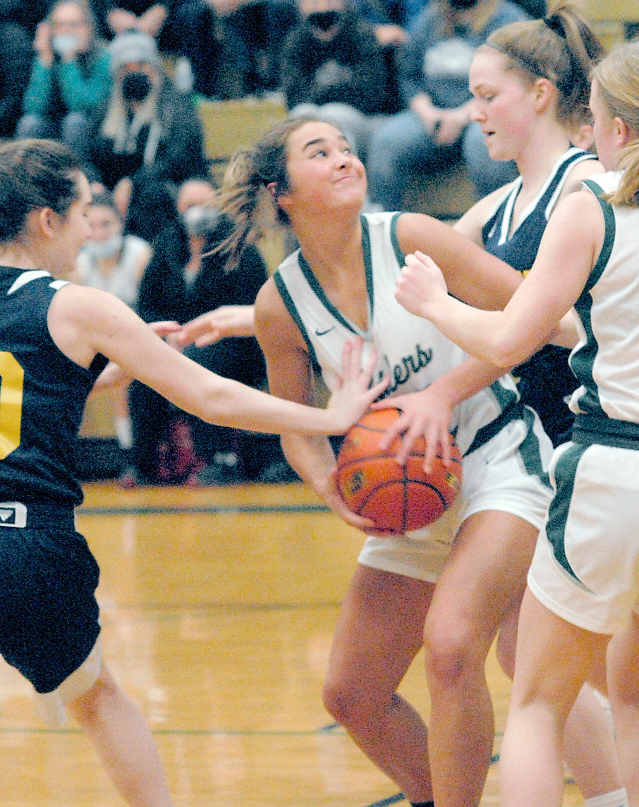 Port Angeles’ Eve Burke, center, looks for the hoop while defended by Bainbridge’s Caroline Payne, left, and Macy Kingrey on Thursday in Port Angeles. (Keith Thorpe/Peninsula Daily News)