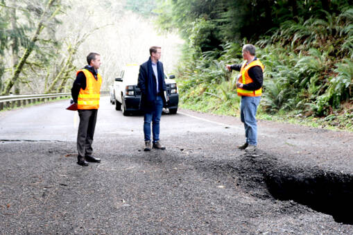 U.S. Rep. Derek Kilmer stands with workers from the state Department of Transportation who assess the damage of a landslide at Highway 112 near milepost 32. (Ken Park/Peninsula Daily News)