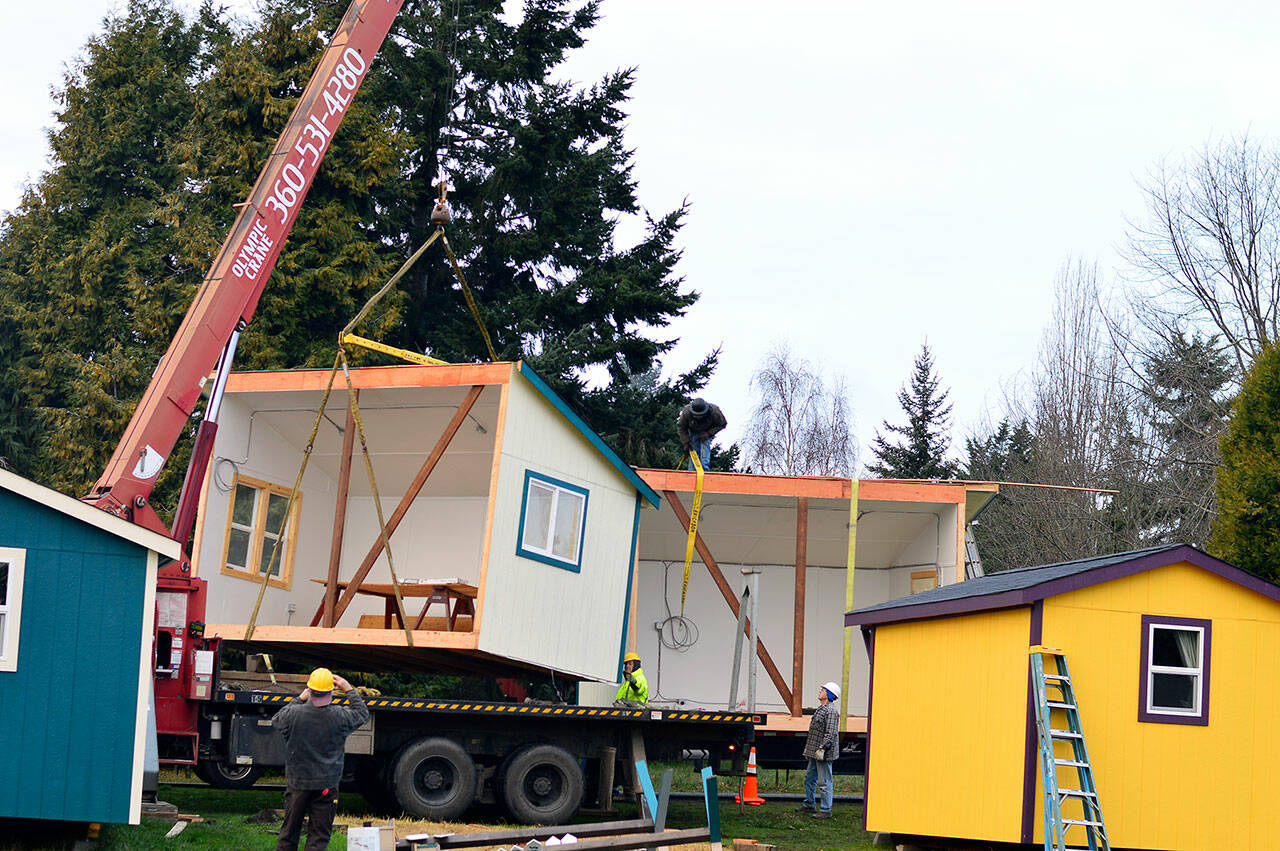 A crane and a crew guide the Pat’s Place kitchen building — divided in half — onto a truck headed for the new transitional housing village in Port Townsend on Tuesday morning. Bayside Housing & Services hopes to open the self-governed and -contained village next month. (Diane Urbani de la Paz/Peninsula Daily News)