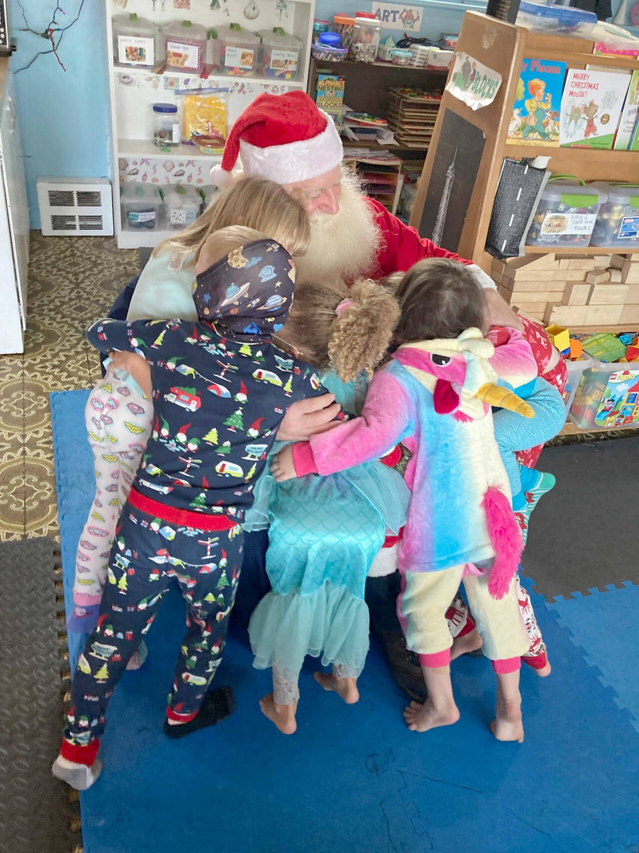 Children at Diane’s Daycare swarm around Barry Swegle during a visit from Santa. (Photo courtesy Diane’s Daycare)