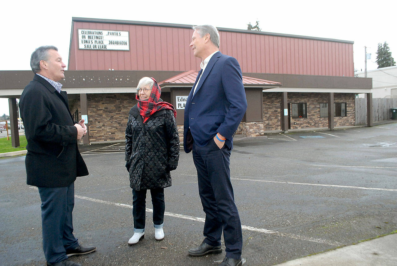 Real estate broker Jim Haguewood, left, speaks with retired businesswoman Edna Peterson and North Olympic Healthcare Network CEO Michael Maxwell outside of Edna’s Place in Port Angeles after the building was acquired from Peterson by the healthcare organization. (Keith Thorpe/Peninsula Daily News)