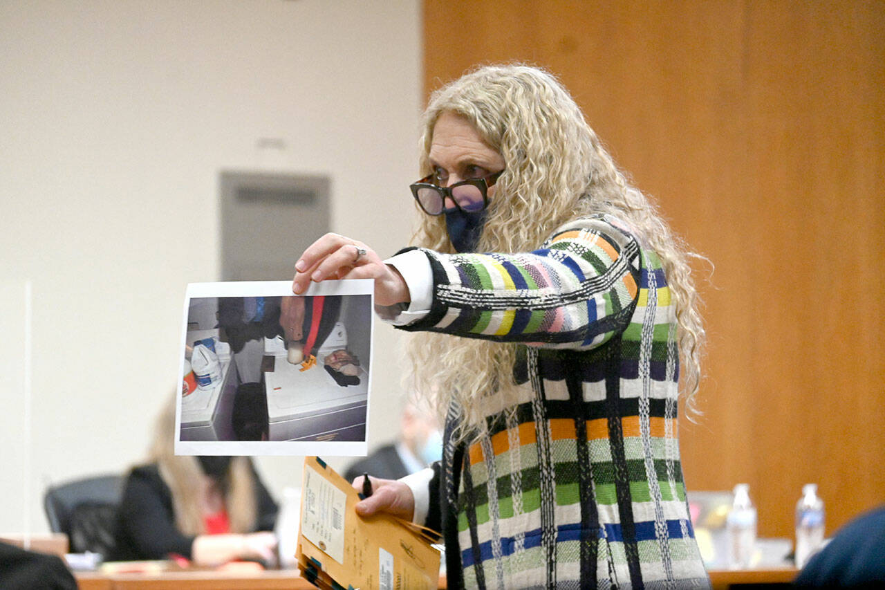 Port Angeles attorney Karen Unger, representing accused triple murderer Dennis Bauer, shows photographic evidence to a jury deciding on Bauer’s fate. (Paul Gottlieb/Peninsula Daily News)