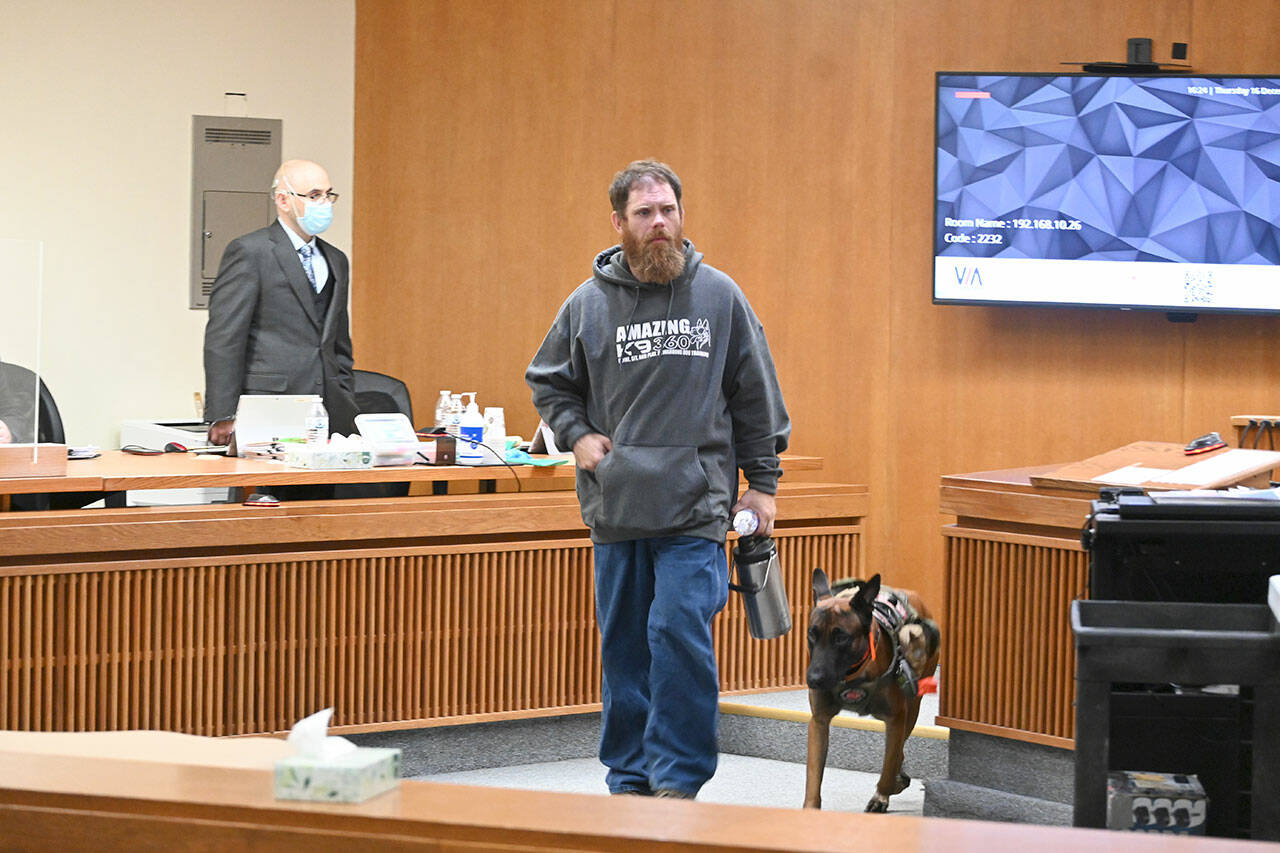 Dustin Iverson and his service dog, Mr. Ryker, leave the courtroom after Iverson testifies at the triple murder trial of Dennis Bauer, accused of killing Iverson’s father. (Paul Gottlieb/Peninsula Daily News)