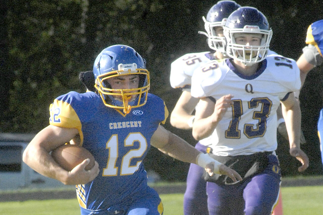 Crescent's Wyatt Lee (12), left, tries to outrun Quilcene's Kevin Alejo (13) in a game in September. Both Lee and Alejo were named to the 8-man All-Peninsula football team. (Keith Thorpe/Peninsula Daily News)