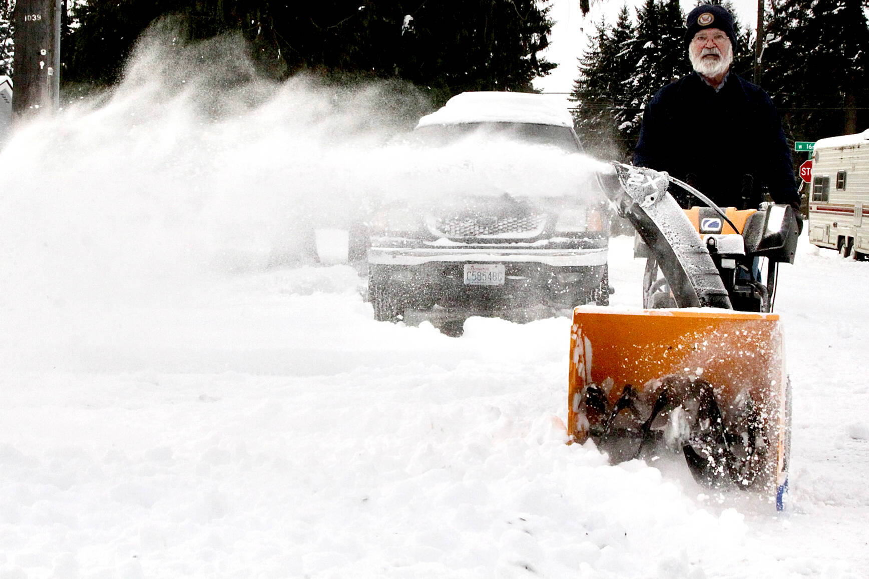 Dave Schroeder of Port Angeles uses a snow blower to clear some of street near 16th and D streets. (Dave Logan/for Peninsula Daily News)