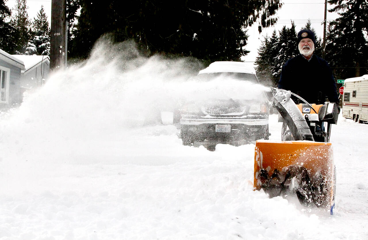 Dave Schroeder of Port Angeles uses a snow blower to clear some of street near 16th and D streets. (Dave Logan/for Peninsula Daily News)