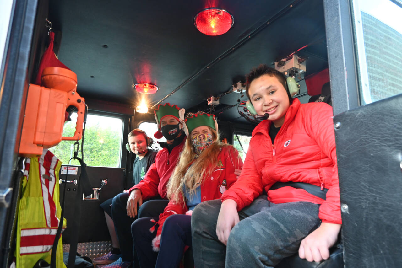 Sequim seventh-graders Michael Lusk, far left, and Kingston Stevens, pictured here with Scott and Laura Lee Johnson, enjoy a ride home in a firetruck in mid-December, thanks to Peninsula Behavioral Health’s “Adventure Auction” on Nov. 6. The auction saw “adventures,” rather than items, auctioned off to raise funds for the entity. Auction items included a helicopter flight, guided hikes and fishing trips. In Port Angeles, a preschool student got a ride to class in a fire truck. (Michael Dashiell/Olympic Peninsula News Group)