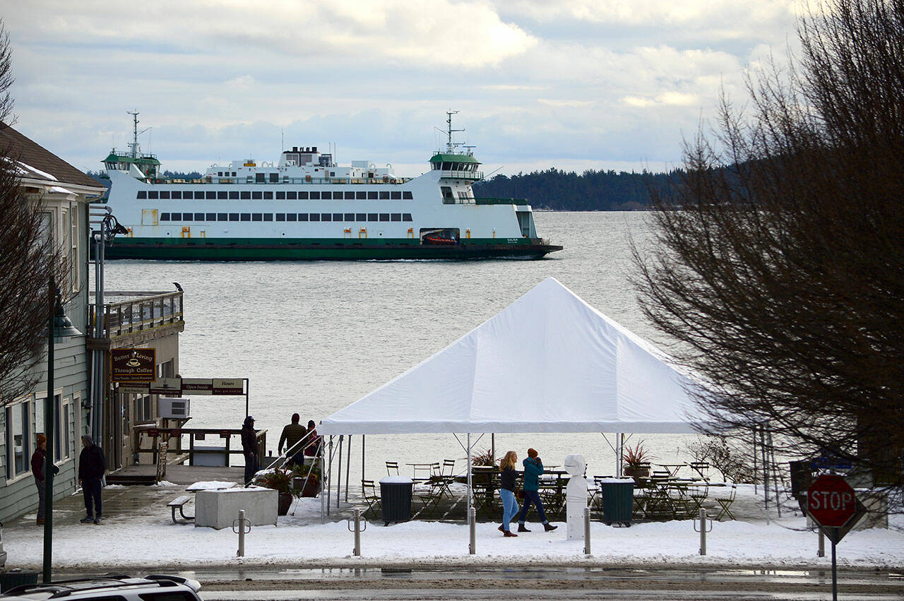 The Washington State Ferry Salish heads for the dock in Port Townsend on Thursday afternoon, passing a snowy Tyler Street Plaza. (Diane Urbani de la Paz/Peninsula Daily News)