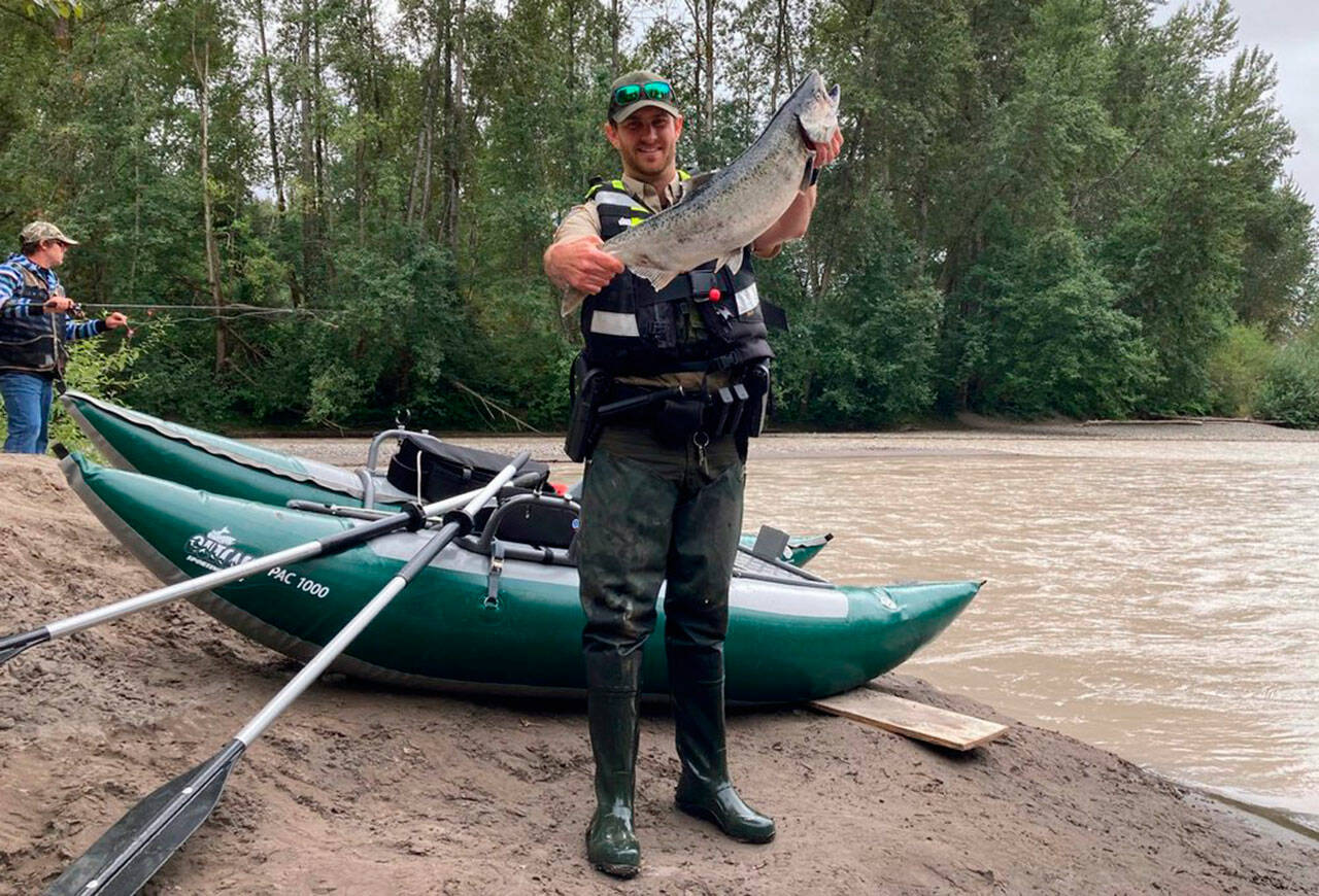 New rafts donated to Washington Department of Fish & Wildlife were used to great effect this summer, fishing advocates say, providing the means to effectively patrol smaller rivers. On a day when a number of citations for violations were written, WDFW officer Patrick Murray holds up a wild chinook an angler had kept after cutting off the adipose fin. (Courtesy of WDFW)