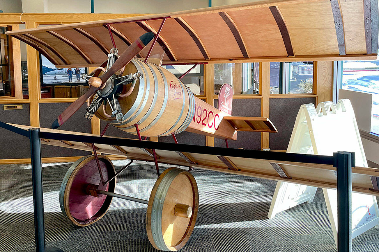 Visitors at Fairchild International Airport have something new to buzz about. Located inside at the entrance of the Airport Terminal Building, “Flight of Fancy,” created by Gene Unger and his partner Don Corson of Camaraderie Cellars Winery, features a handmade aircraft constructed out of parts of wine barrels. The tail number N92CC represents the first vintage year of the winery, 1992. (Scott Gardinier/Peninsula Daily News)