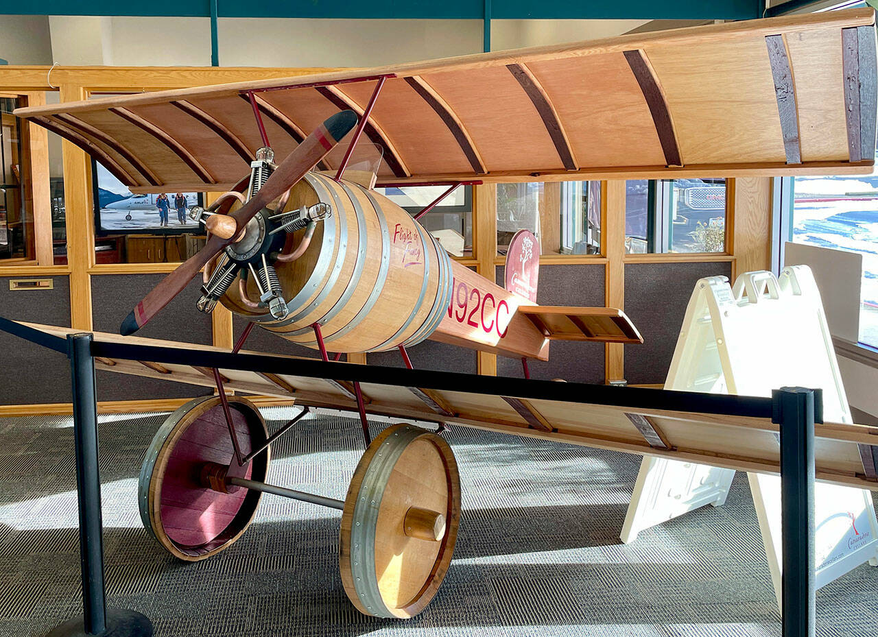 Visitors at Fairchild International Airport have something new to buzz about. Located inside at the entrance of the Airport Terminal Building, “Flight of Fancy,” created by Gene Unger and his partner Don Corson of Camaraderie Cellars Winery, features a handmade aircraft constructed out of parts of wine barrels. The tail number N92CC represents the first vintage year of the winery, 1992. (Scott Gardinier/Peninsula Daily News)