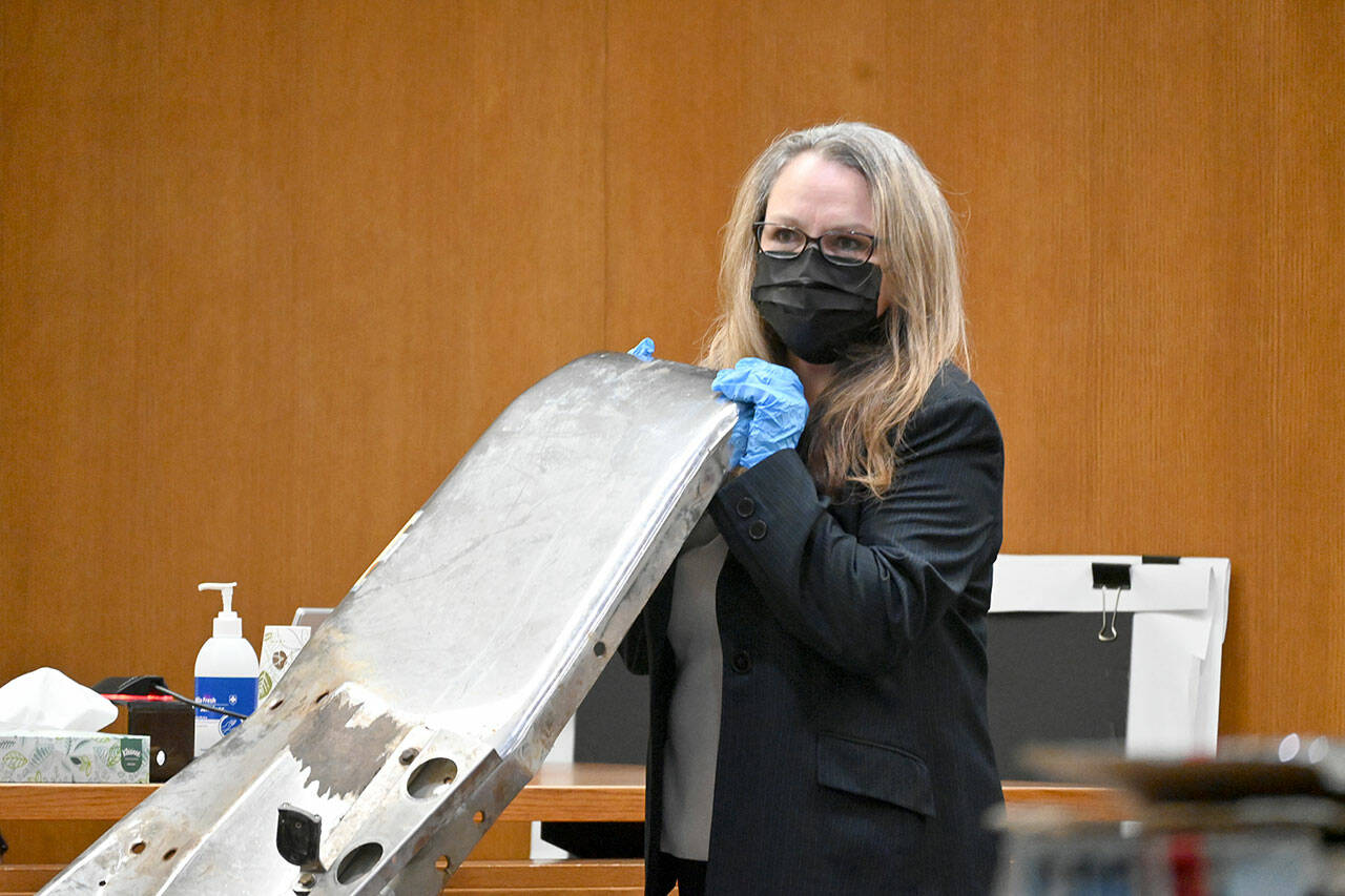 Paul Gottlieb/Peninsula Daily News
During closing arguments Thursday at Dennis Bauer's triple murder trial, Michele Devlin, chief criminal deputy prosecuting attorney, displays to the jury a truck bumper found on the body of victim Jordan Iverson.