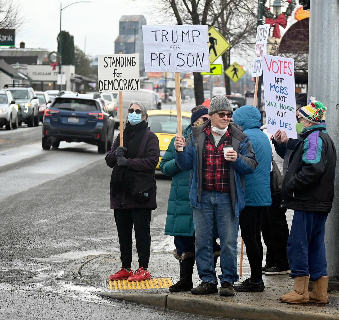 At least 125 people stand on the corners of Washington Street and Sequim Avenue on Thursday morning for a vigil on the one-year anniversary of the Jan. 6 insurrection at the U.S. Capitol. The vigil was hosted by Indivisible Sequim. Later in the day, the League of Women Voters of Jefferson County hosted in Port Townsend a candlelight vigil to remember the law enforcement officers killed or wounded on duty at the Capitol on Jan. 6 and to show support for voting rights. (Emily Matthiessen/Olympic Peninsula News Group)