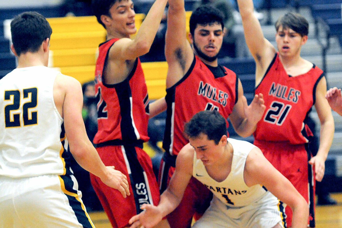 Forks' Riley Pursley (1) eyes the ball beneath the Wahkiakum defense from left Titan Niemela, Dominic Curl, and Tanner Collupy.  Looking on is Spartan Brody Lausche (22).  Photo by Lonnie Archibald.
