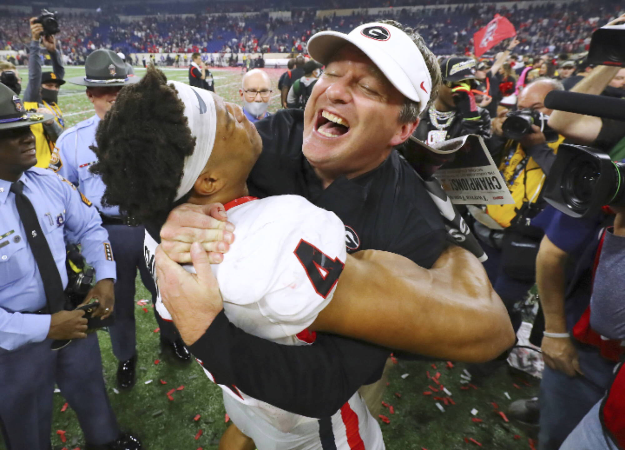 Georgia head coach Kirby Smart celebrates winning the College Football Playoff Championship game against Alabama, getting a hoist from outside linebacker Bolan Smith, early Tuesday, Jan. 11, 2022, in Indianapolis. (Curtis Compton/Atlanta Journal-Constitution via AP)