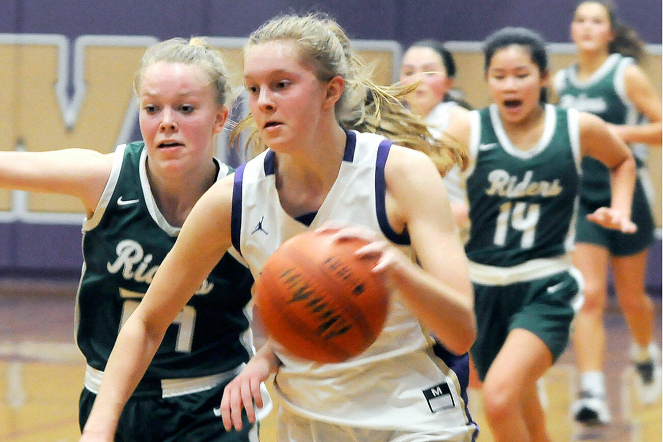 Michael Dashiell/Olympic Peninsula News Group
Sequim's Jolene Vaara, right, dribbles upcourt while Port Angeles' Anna Petty attempts to shield Vaara from heading to the basket during the Wolves' 60-55 win over the Roughriders.