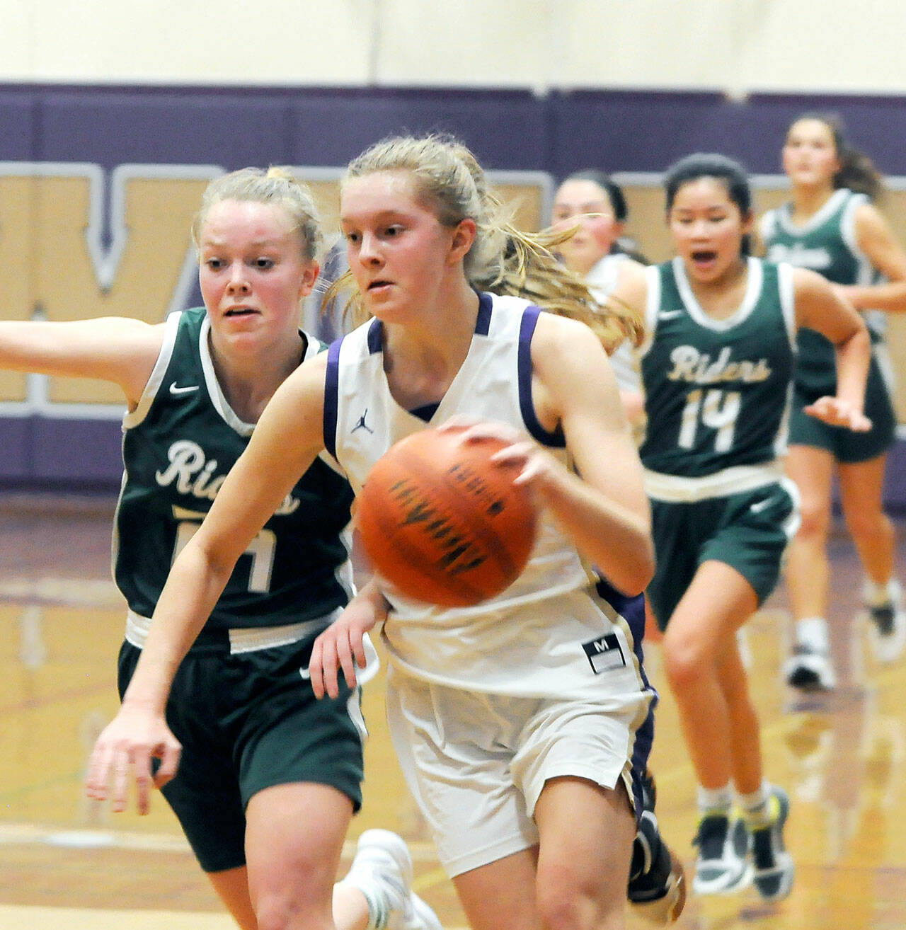 Michael Dashiell/Olympic Peninsula News Group Sequim’s Jolene Vaara, right, dribbles upcourt while Port Angeles’ Anna Petty attempts to shield Vaara from heading to the basket during the Wolves’ 60-55 win over the Roughriders.