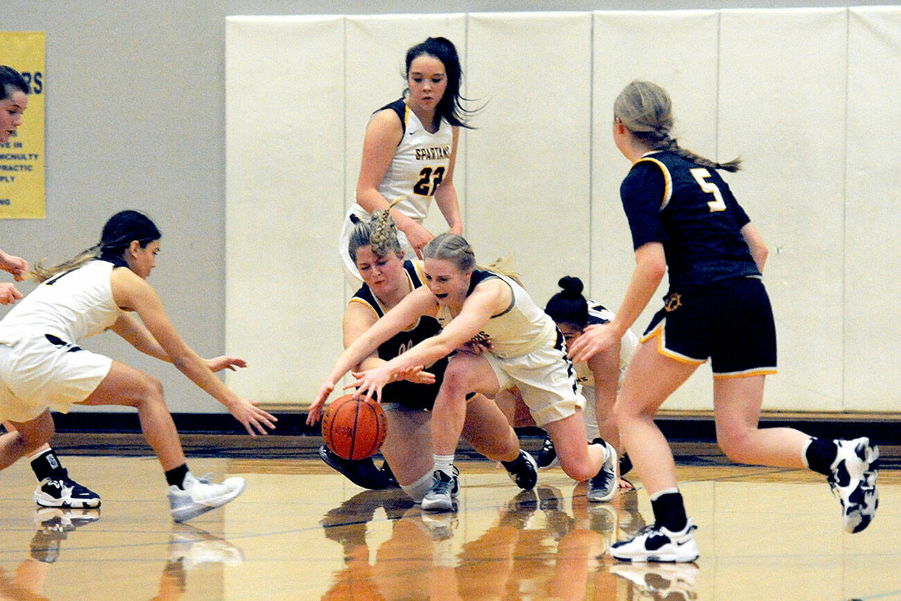 Lonnie Archibald/for Peninsula Daily News
Forks Candida-Rose Sandoval (left) and Kadie Wood compete with Ilwaco's Olivia McKinstry for ball control during the Spartans' 59-38 win over the Fishermen. Looking on are Forks' Brynn Daniels and Ilwaco's Zoey Zuern.
