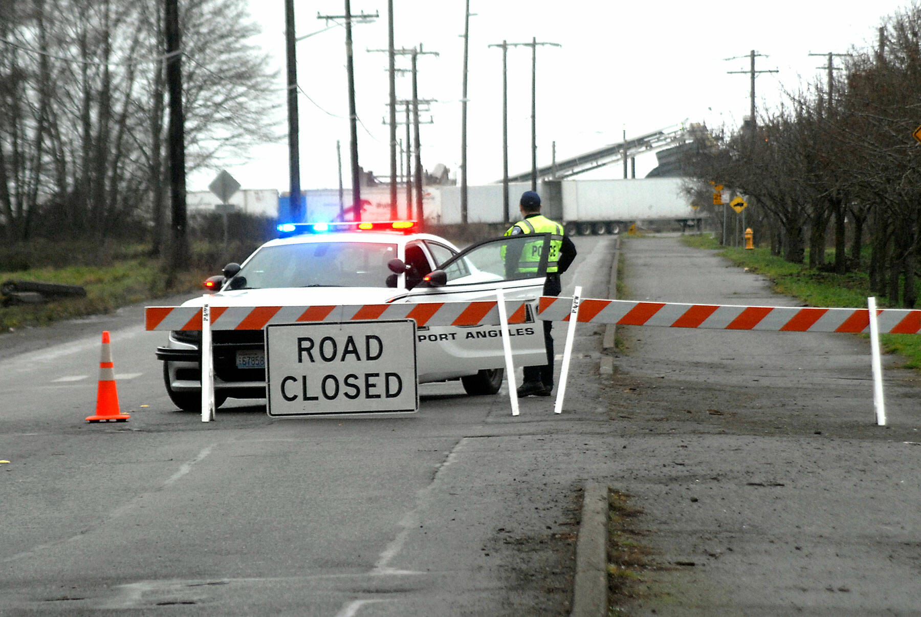 A police roadblock at Marine Drive at Hill Street bars unauthorized traffic from access to Ediz Hook Road on Saturday afternoon. The road closure started earlier in the day at the McKinley Paper Mill site and later extended. (Keith Thorpe/Peninsula Daily News)