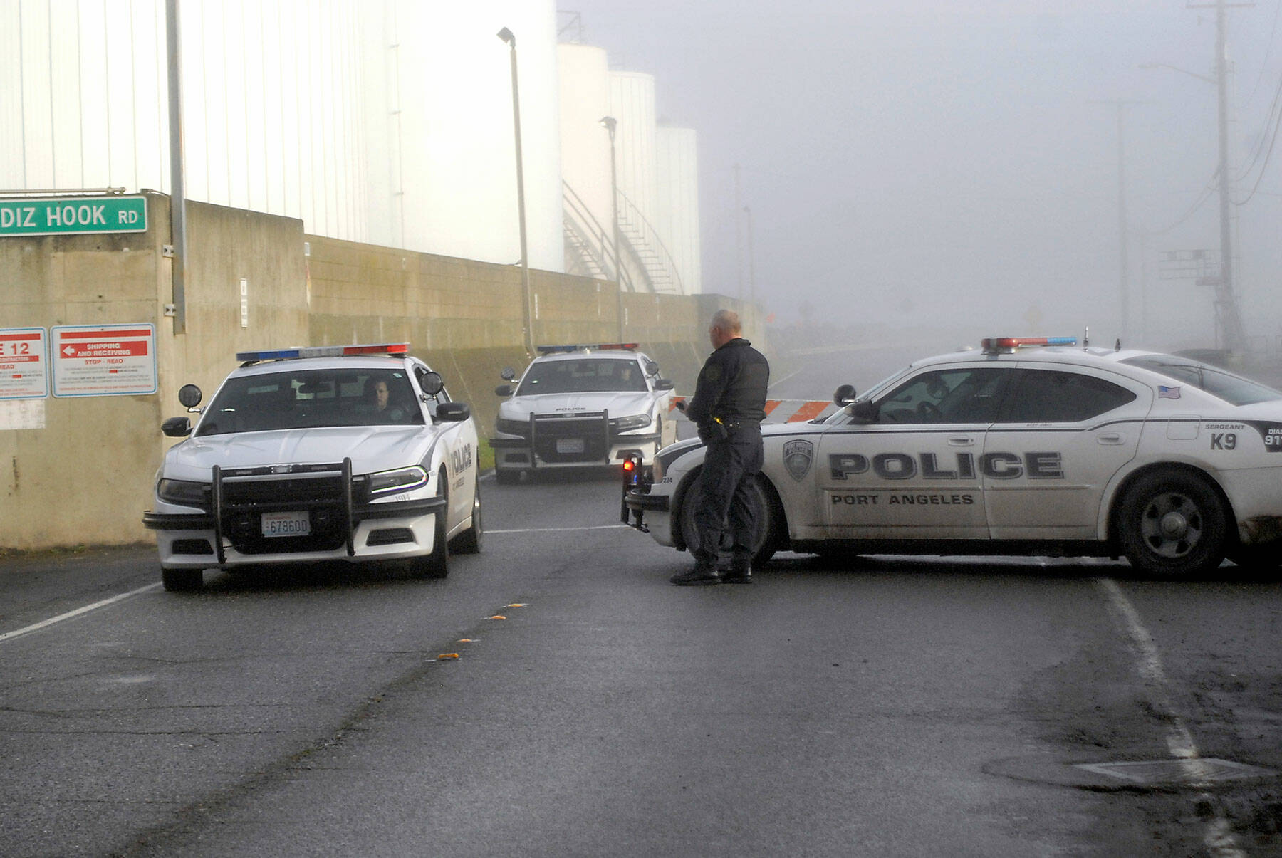 Keith Thorpe/Peninsula Daily News
Port Angeles police Sgt. Kevin Miller blocks the entrance to Ediz Hook Road along Port Angeles Harbor as two police cars leave the area after the hook was evacuated of civilians during a tsunami advisory Saturday morning.