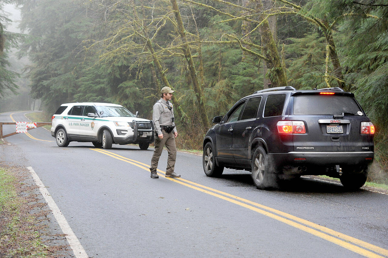 Olympic National Park Ranger Chris Erickson of Port Angeles stops beachgoers at the Mora Ranger Station as Rialto Beach was closed to visitors due to possible tsunami. (Lonnie Archibald/for Peninsula Daily News)