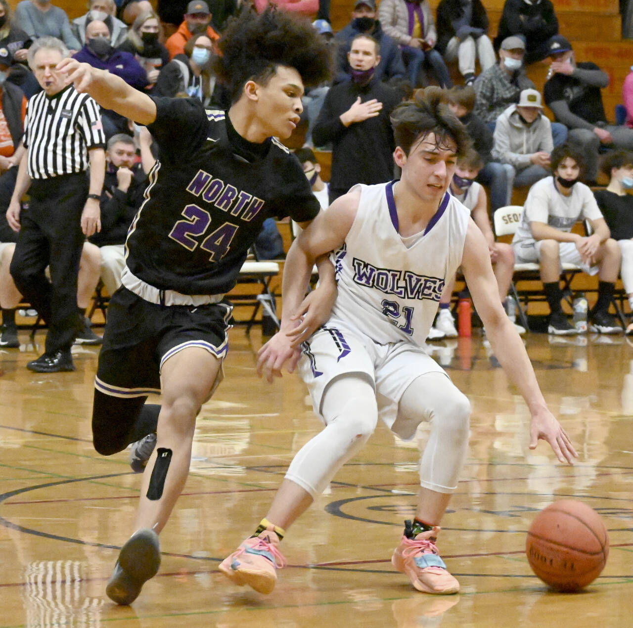Sequim’s Jaydin Possin (21) dribbles against the defense of North Kitsap’s Jalen East on Thursday in Sequim. (Michael Dashiell/Olympic Peninsula News Group)