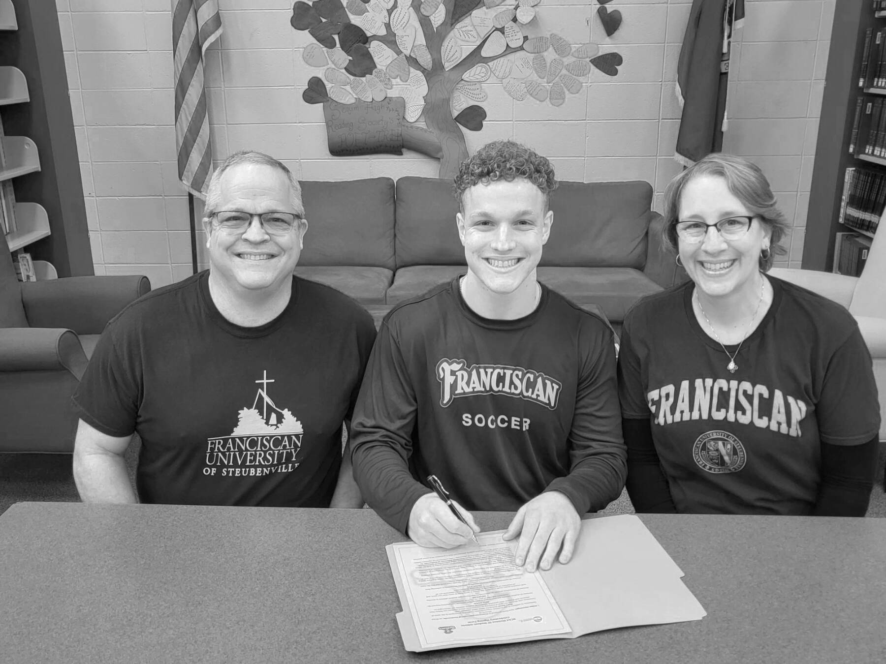 Aiden Henninger of Sequim, with his father, Ray, left and mother Ann Marie Henninger, signs to play soccer at Franciscan University in Steubenville, Ohio.