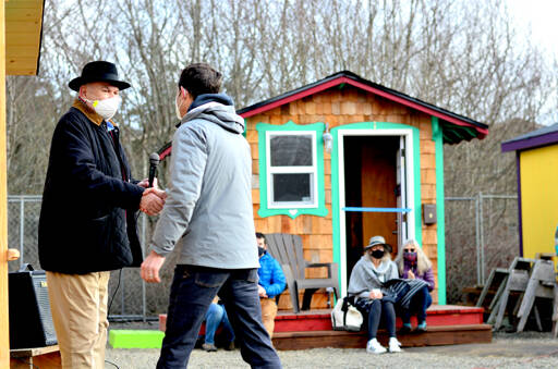 Bayside Housing & Services director Gary Keister, left, welcomes Port Townsend City Manager John Mauro to Pat’s Place, the new tiny home village, at Saturday afternoon’s blessing ceremony. (Diane Urbani de la Paz/Peninsula Daily News)