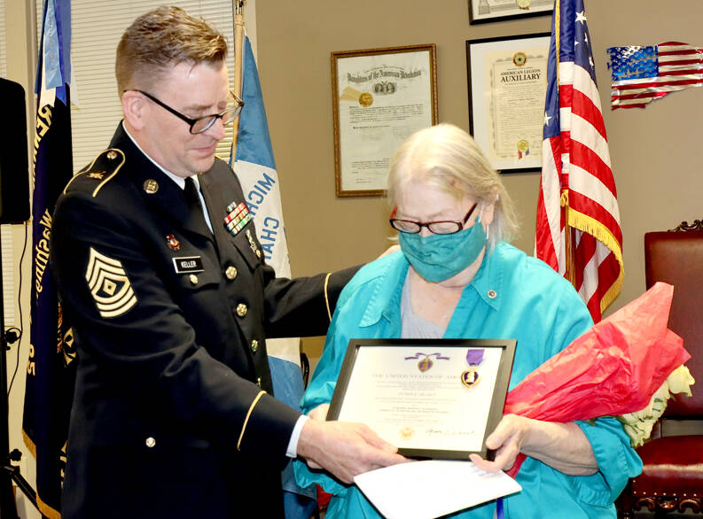 By Dave Logan/For Peninsula Daily News 

First Sgt. Kent Keller of Sequim, left, presents to Linda Featheringill of Port Angeles the Purple Heart her brother was never able to receive in person as well as a United States of America War Office document. Her brother, Army Cpl. Marvin D. Actkinson, was declared missing in action in Korea on Dec. 2, 1950 and presumed dead in 1953. He was 18. His remains were returned in 2018 and will be buried in Colorado City, Texas, on Feb. 12. The Thursday ceremony was hosted by the Michael Trebert Chapter of the Daughters of the American Revolution at the Northwest Veterans Resource Center in Port Angeles. Featheringill was accompanied by her daughter Eilenah Moon. About 70 people attended the ceremony, which honored Actkinson 71 years after his death.