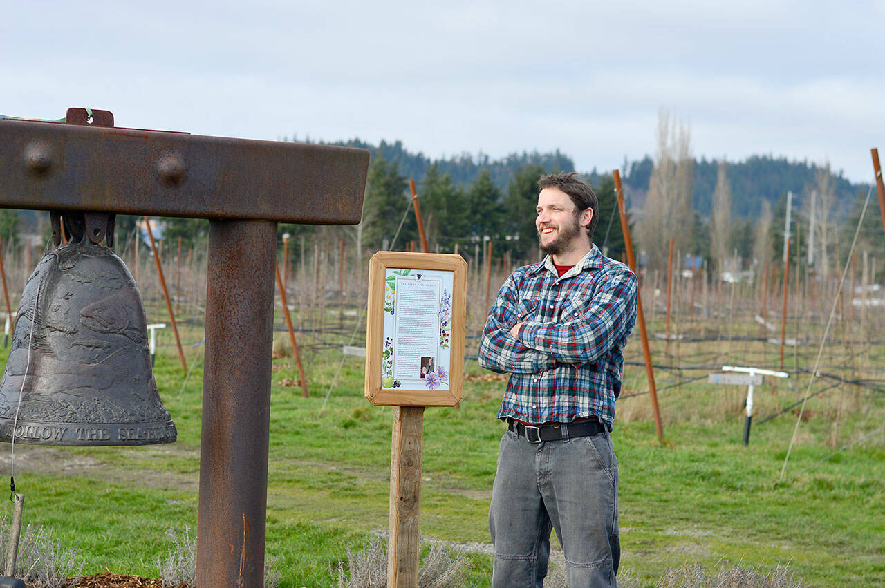 Cidermaker Andrew Byers of Finnriver Farm & Cidery, winner of the Good Food Award for its Perry pear wine, stands beside the farms Watershed Bell, cast by the late Tom Jay. (Diane Urbani de la Paz/Peninsula Daily News)