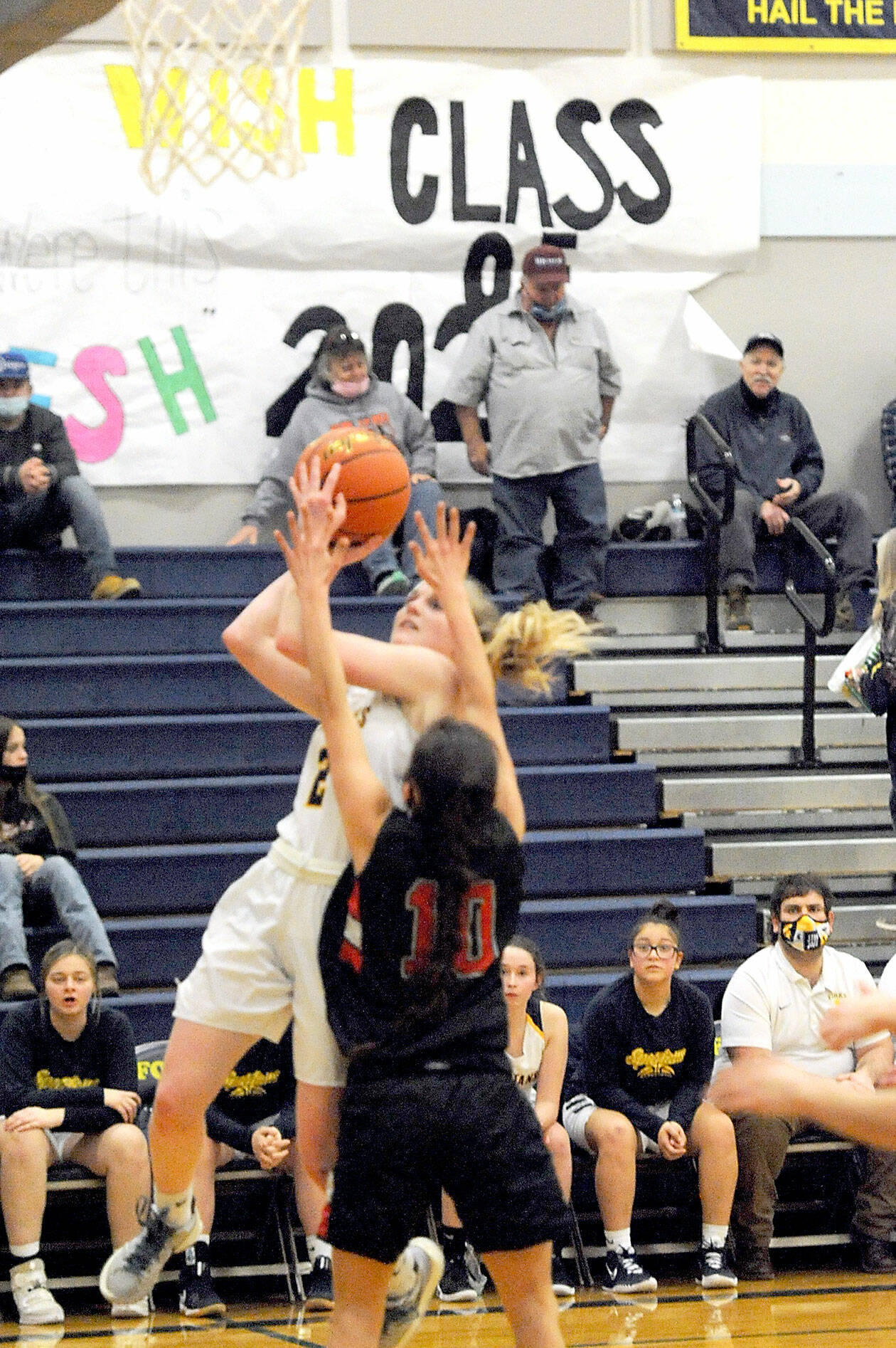 Forks’ Kadie Wood shoots over the defense of Neah Bay’s Allie Greene during the Red Devils’ 67-35 win over the Spartans on Monday. (Lonnie Archibald/for Peninsula Daily News)