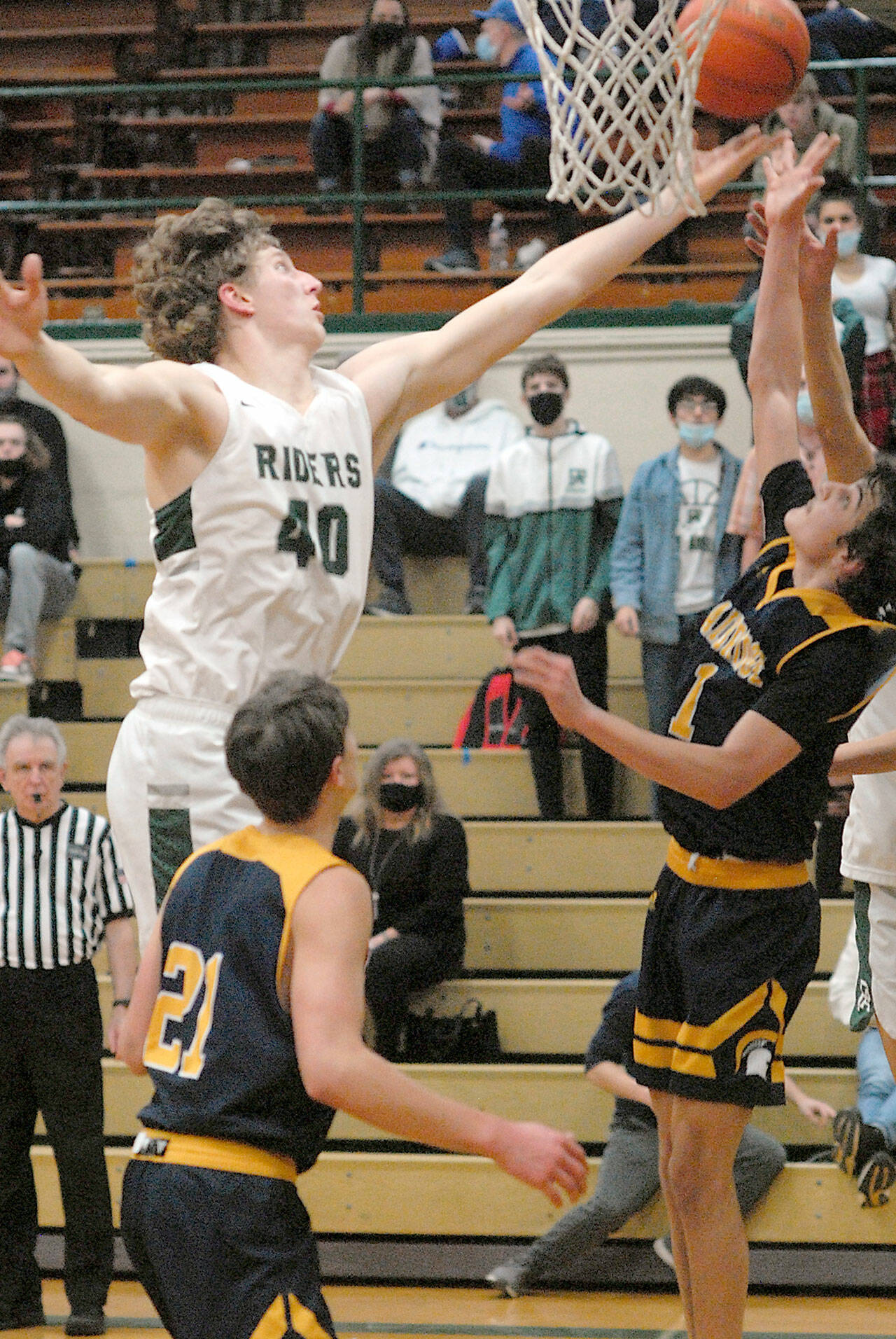 Port Angeles’ John Vaara, left, aims for the hoop defended by Bainbridge Island’s Everett Moore, front, and Charlie Diiorio Triesch on Tuesday night at Port Angeles High School. (Keith Thorpe/Peninsula Daily News)