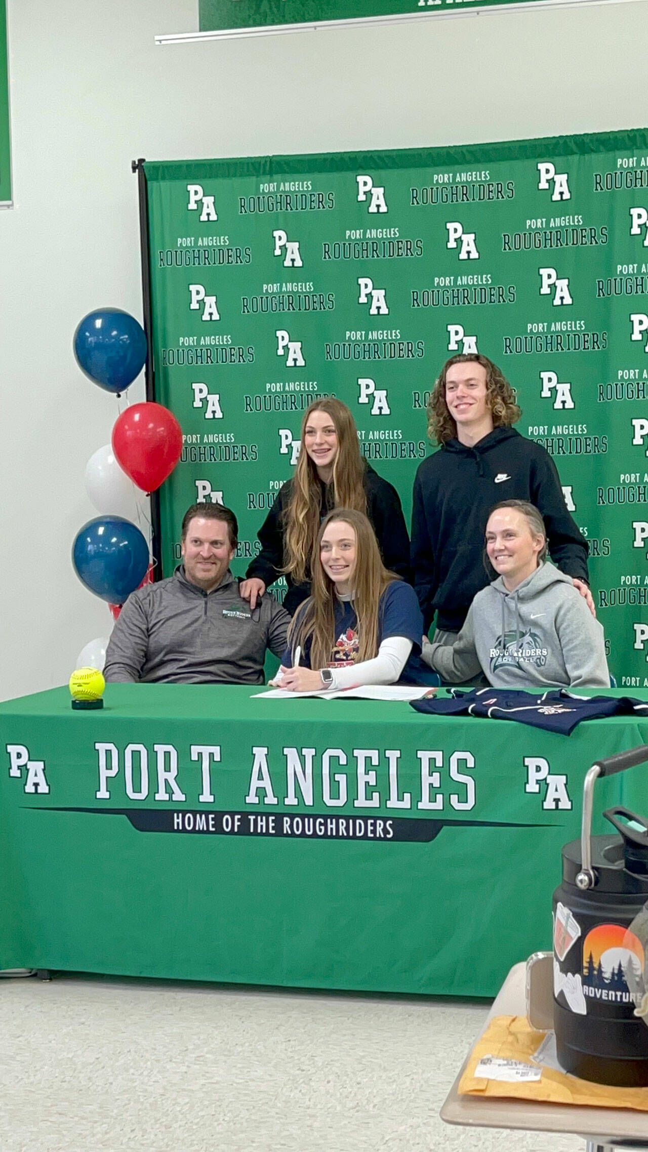 Port Angeles senior Teagan Clark, seated at center, signs a letter of intent to play softball at Skagit Valley College with her family in attendance including dad Dustin Clark, mom Tasha Clark, sister Teanna and brother Dru.