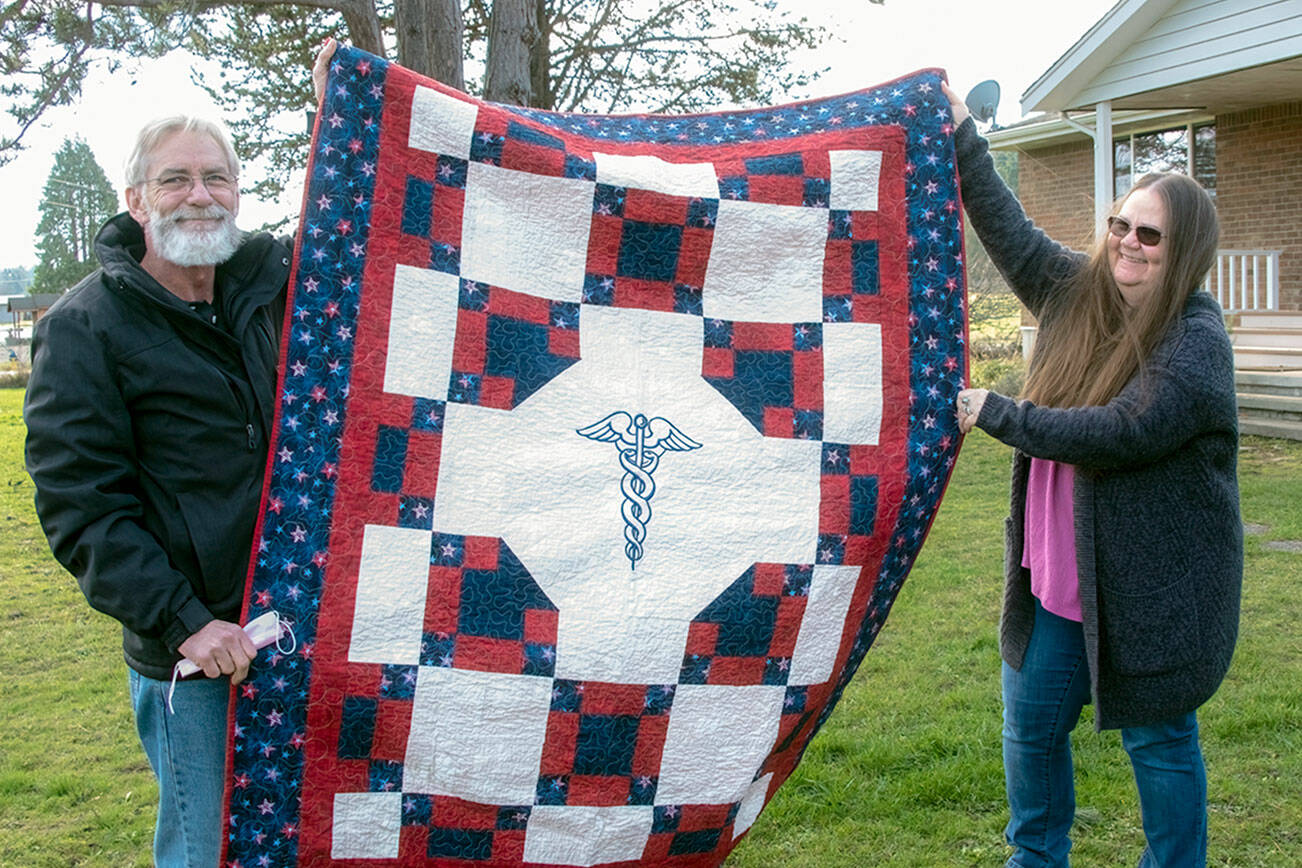 Jon and Valkyrie Ferguson hold up the Quilts of Valor quilt given to Valkyrie earlier this month. photo by Chris Bates
