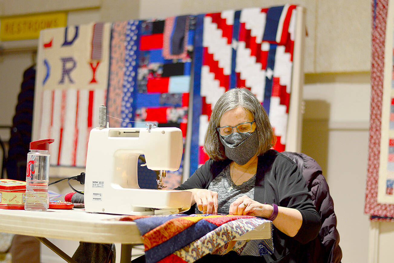 Marilee Martin works among with 10 women during the Quilts of Valor Sewing Day at the American Legion hall in Port Townsend on Saturday. The quilts are given free to veterans across the state and country. To request a quilt for a veteran, visit www.QOVF.org, and for more information about the North Olympic Peninsula’s Quilts of Valor chapter, contact team leader Kathey Bates at 1katheybates@gmail.com. (Diane Urbani de la Paz/Peninsula Daily News)