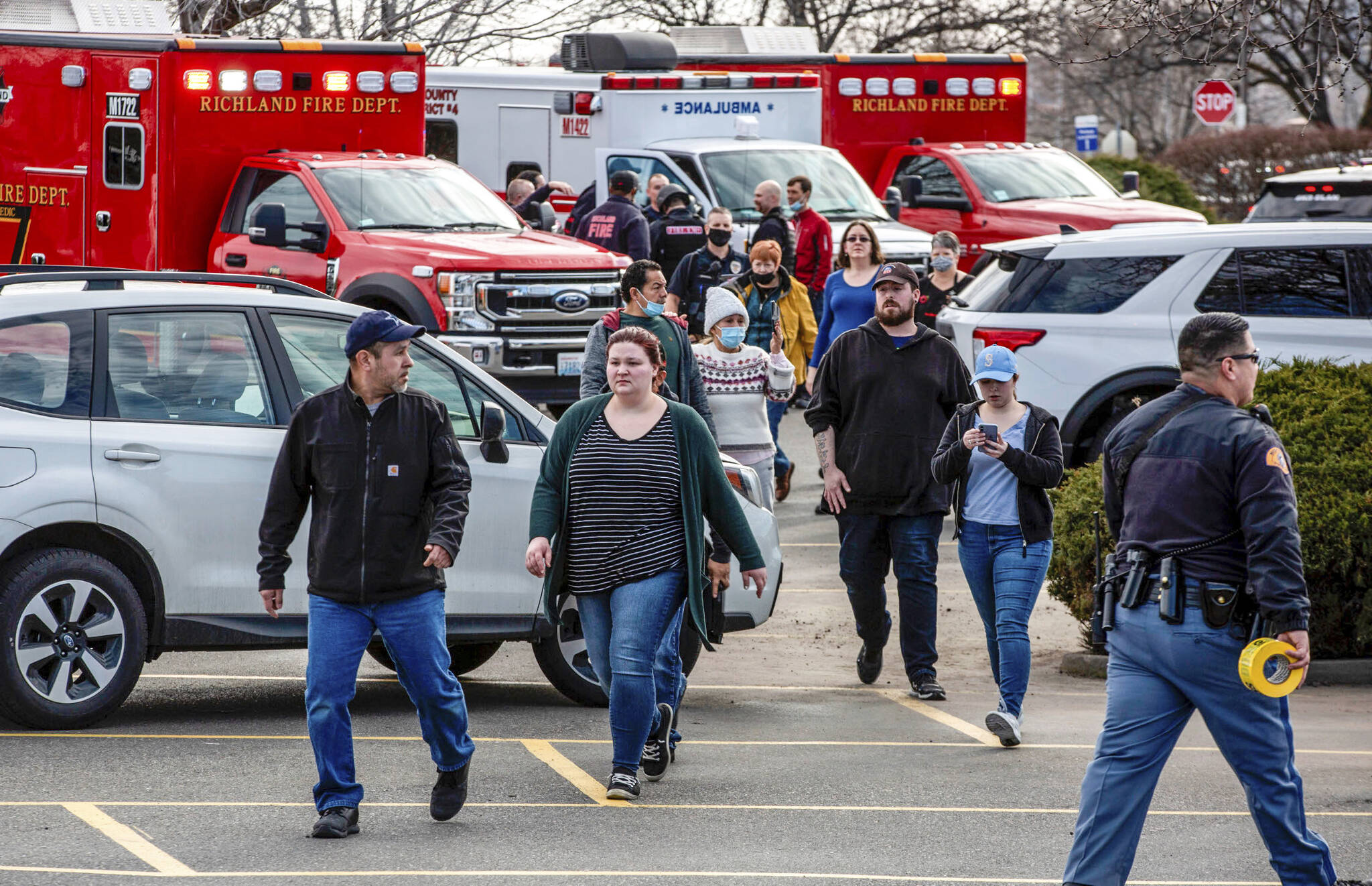 Customers and employees are guided out of a Fred Meyer grocery store after a fatal shooting at the business on Wellsian Way in Richland, Wash., Monday, Feb. 7, 2022. (Jennifer King/The News Tribune via AP)