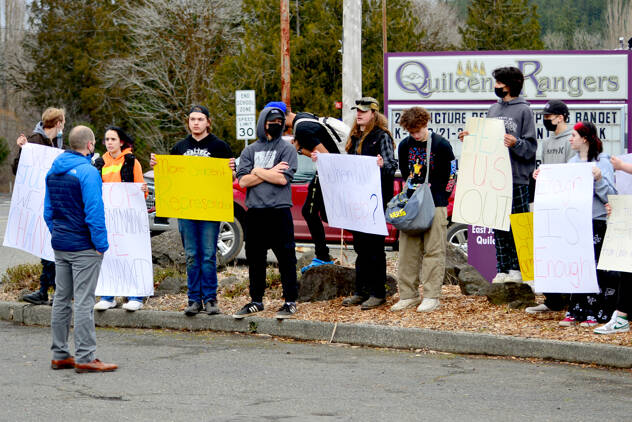 Quilcene High School principal Sean Moss, left, faces a group of students who walked out of class Tuesday afternoon, protesting what they say is a lack of support for students who have been sick with COVID-19. (Diane Urbani de la Paz/Peninsula Daily News)