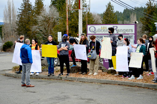 Quilcene High School principal Sean Moss, left, faces a group of students who walked out of class Tuesday afternoon, protesting what they say is a lack of support for students who have been sick with COVID-19. (Diane Urbani de la Paz/Peninsula Daily News)