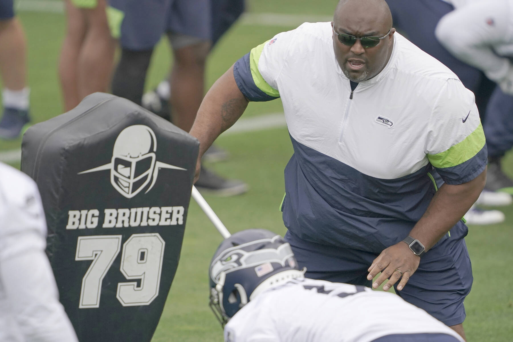 Seattle Seahawks defensive line and assistant head coach Clint Hurtt, right, runs a drill during NFL football practice Tuesday, June 15, 2021, in Renton, Wash. (AP Photo/Ted S. Warren)