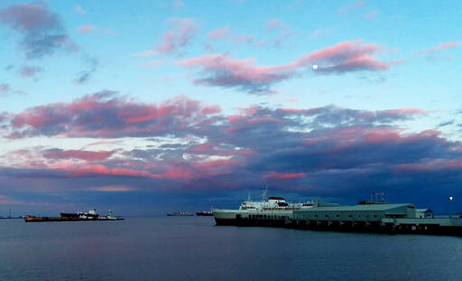 The Coho ferry arrives in Port Angeles from Victoria on Monday afternoon as the sun sets and the moon rises. The Canadian government announced the following day that, starting Feb. 28, travelers have the option of using a COVID-19 rapid antigen test rather than a PCR test, so long as it is administered by a health care professional. Also, “on arrival” in Canada, testing requirements will be eased for those who are fully vaccinated against the virus. (Pierre LaBossiere/Peninsula Daily News)