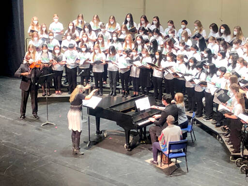 Jolene Dalton Gailey of Port Angeles conducts the Junior All-State Treble Choir in concert at the Capitol Theatre last Saturday with James Ray, Gailey’s former Port Angeles High School colleague, playing violin at left. (Monika Tabor)